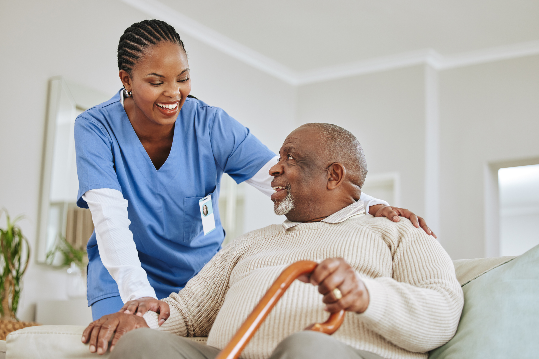 A female health care worker talks with an elderly male patient