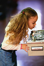 A young girl drinks from a public water fountain.