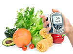 Hand holds blood glucose monitor that reads, 104 in front of fruits and vegetables, represents diabetes prevention programs.