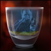 The image of a man drinking alcohol is reflected in a shot glass