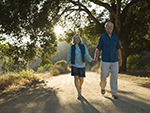 An older couple walking along a pathway in the woods