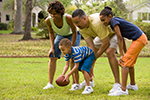 A family plays American style football in their yard