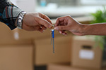 One person handing a set of keys to a second person.