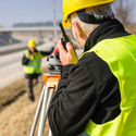 A survey crew takes measurements along a highway.